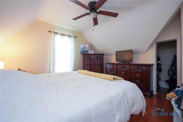 bedroom with ceiling fan, vaulted ceiling, and dark hardwood / wood-style flooring