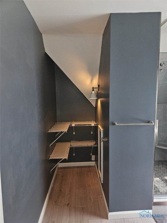 staircase featuring lofted ceiling and wood-type flooring