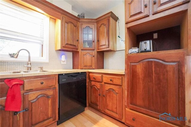 kitchen featuring light hardwood / wood-style floors, sink, backsplash, and dishwasher