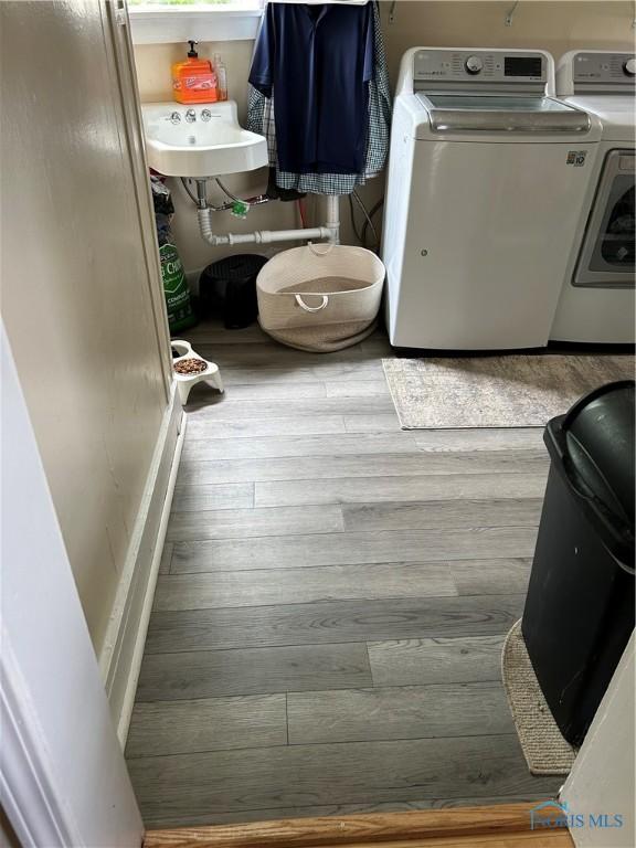 laundry room featuring hardwood / wood-style flooring and washer and clothes dryer