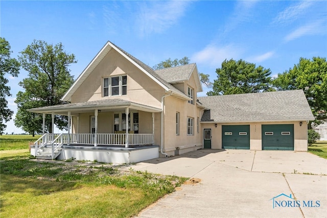 view of front of property featuring a porch, a garage, and a front yard