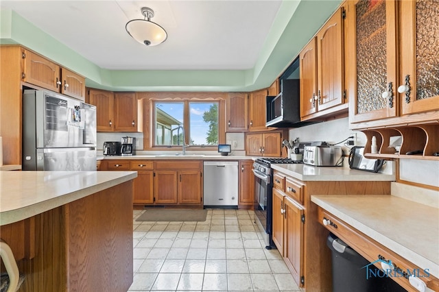 kitchen with sink, light tile patterned floors, and appliances with stainless steel finishes