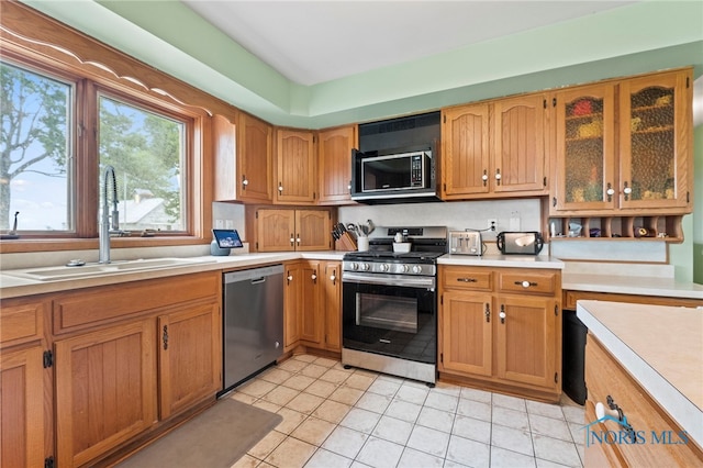 kitchen with appliances with stainless steel finishes, light tile patterned floors, and sink