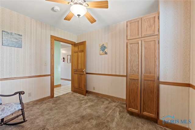 interior space featuring ceiling fan and light carpet