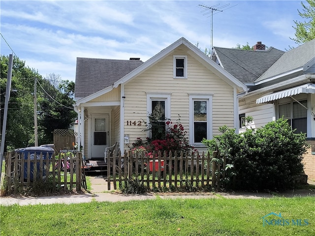 rear view of property featuring a lawn