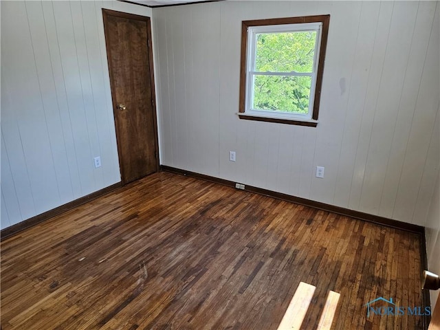 unfurnished room featuring dark hardwood / wood-style flooring