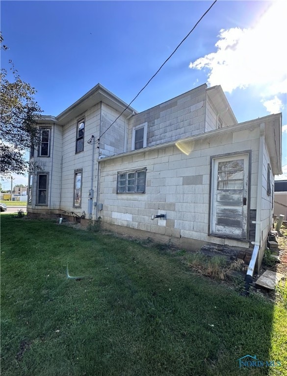 back of house with a lawn