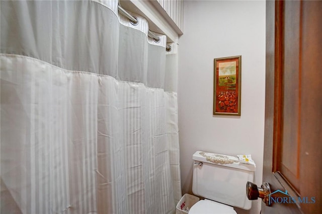 bathroom featuring a shower with shower curtain and toilet