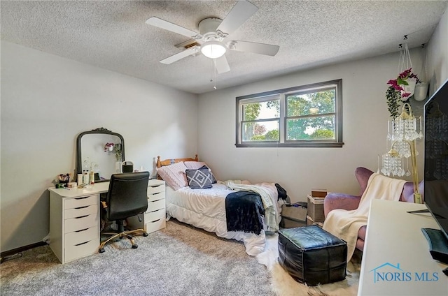 bedroom featuring carpet flooring, a textured ceiling, and ceiling fan