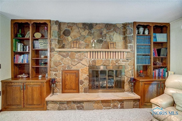 carpeted living room with a stone fireplace