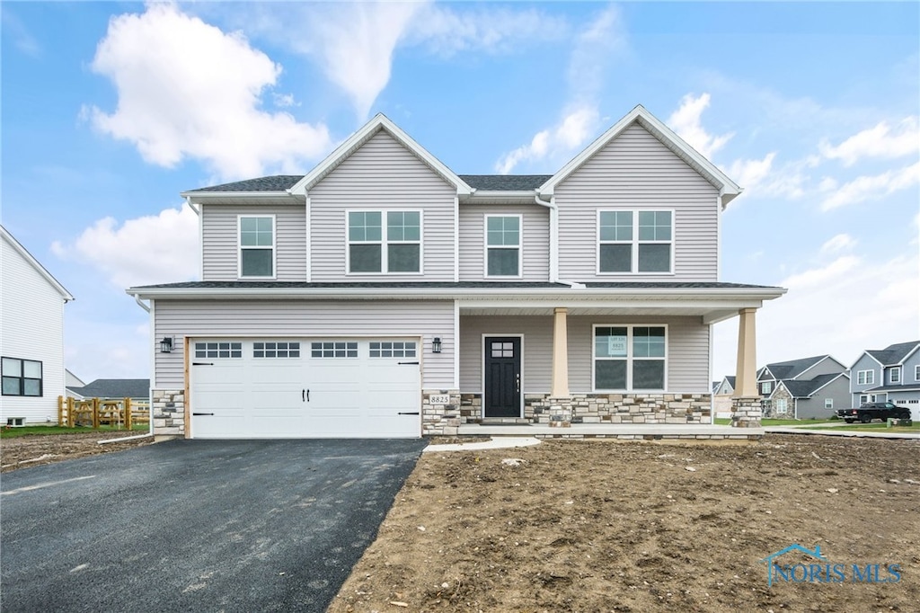 view of front of home featuring covered porch and a garage