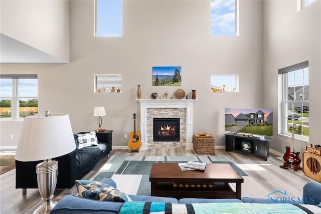 living room featuring a fireplace, wood-type flooring, and a high ceiling