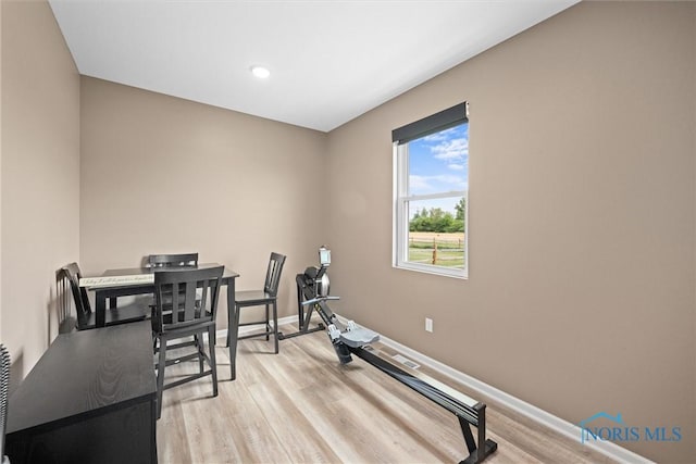 workout area with light hardwood / wood-style flooring