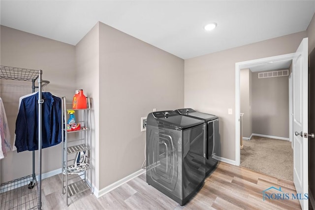 clothes washing area featuring hardwood / wood-style floors and independent washer and dryer