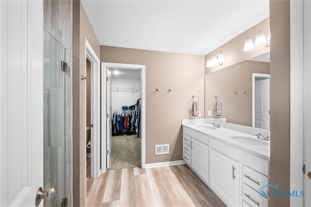 bathroom with vanity, an enclosed shower, and hardwood / wood-style floors