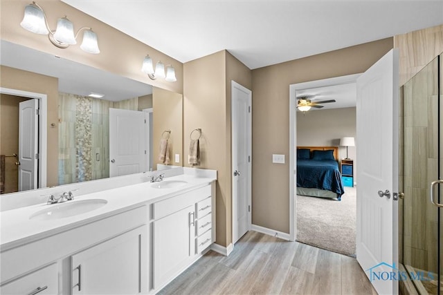 bathroom with hardwood / wood-style flooring, vanity, an enclosed shower, and ceiling fan