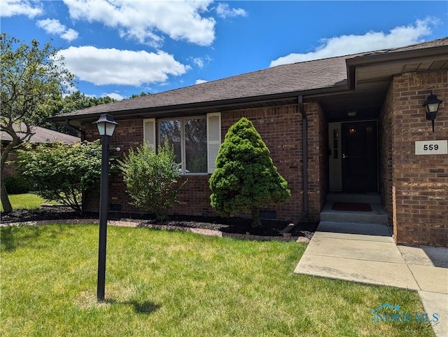 entrance to property featuring a lawn