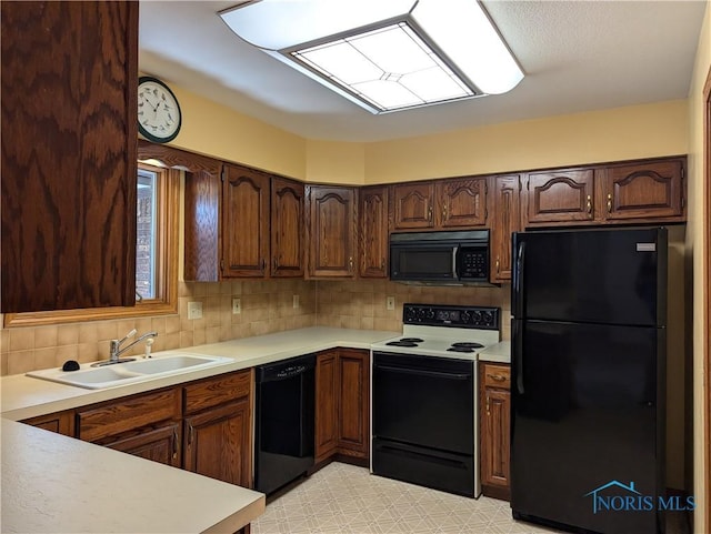 kitchen featuring black appliances, decorative backsplash, and sink