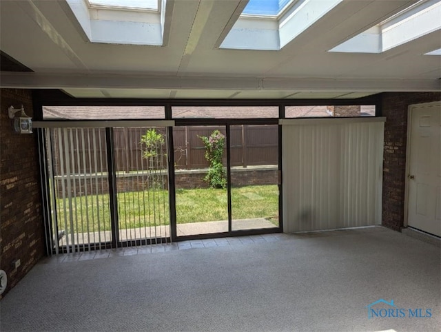 interior space featuring carpet flooring and brick wall