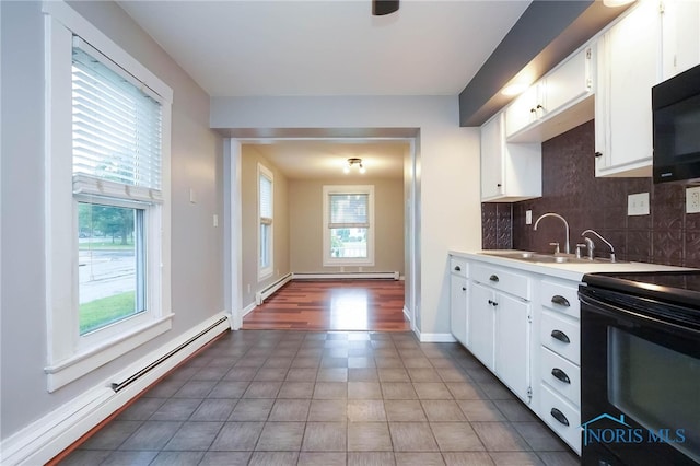 kitchen featuring a baseboard radiator, decorative backsplash, dark tile patterned flooring, and white cabinets