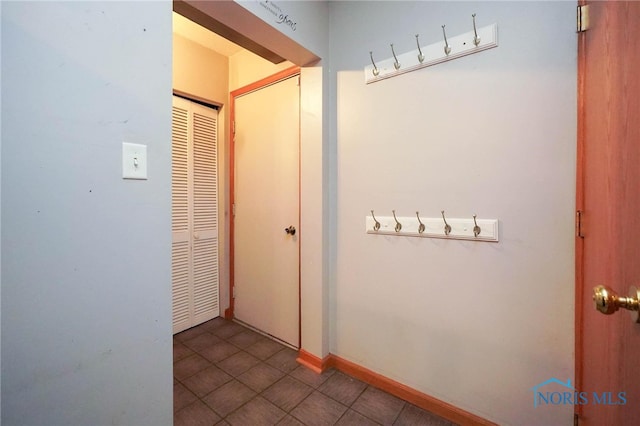 hall with dark tile patterned flooring