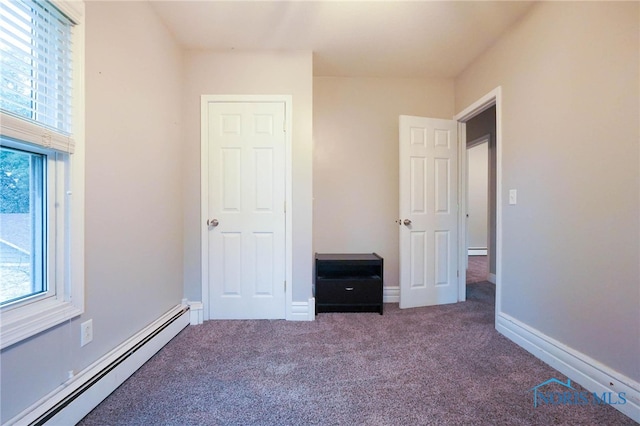 unfurnished bedroom featuring carpet and baseboard heating