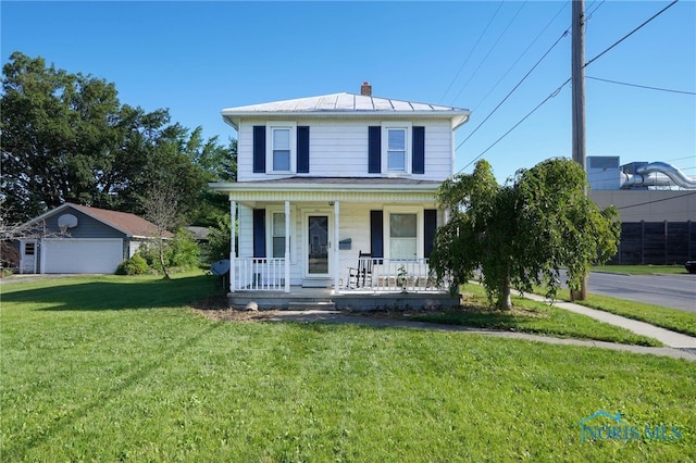 front of property with a garage, covered porch, an outdoor structure, and a front yard