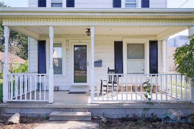 view of exterior entry featuring covered porch