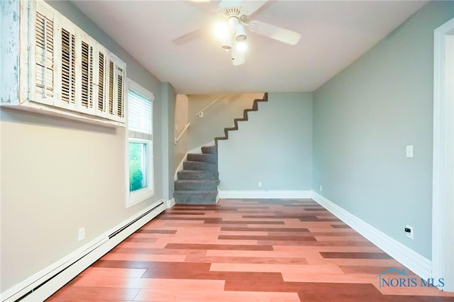 interior space with a baseboard heating unit, wood-type flooring, and ceiling fan