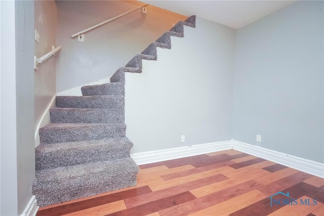 stairway with hardwood / wood-style floors