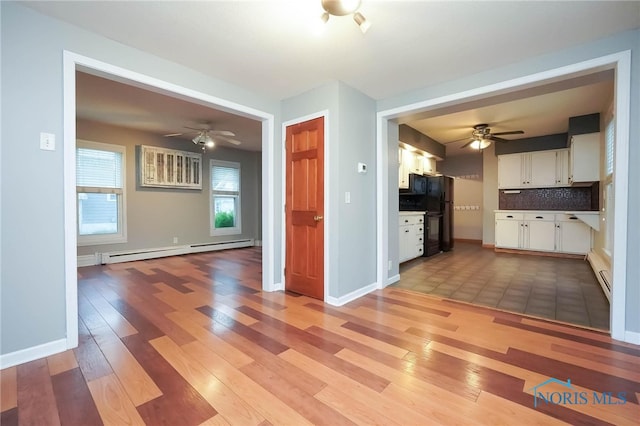 unfurnished living room featuring light tile patterned flooring, ceiling fan, and baseboard heating