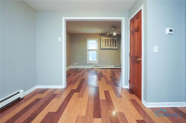 corridor with a baseboard radiator and hardwood / wood-style floors