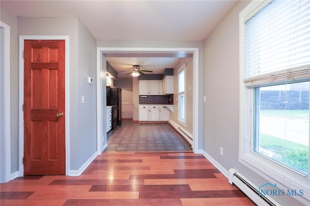 corridor featuring tile patterned floors and baseboard heating