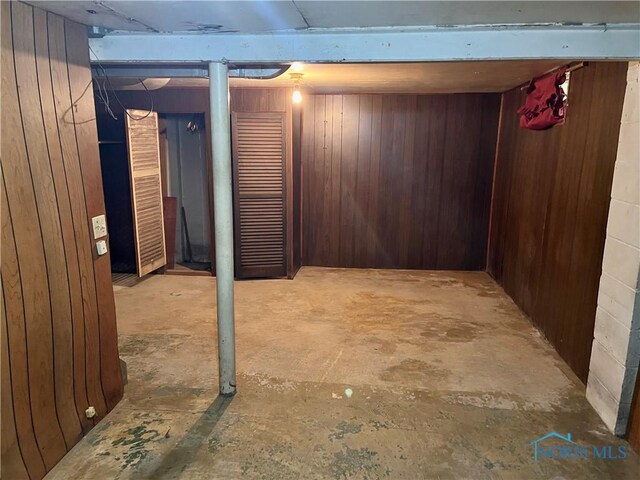 basement featuring wooden walls