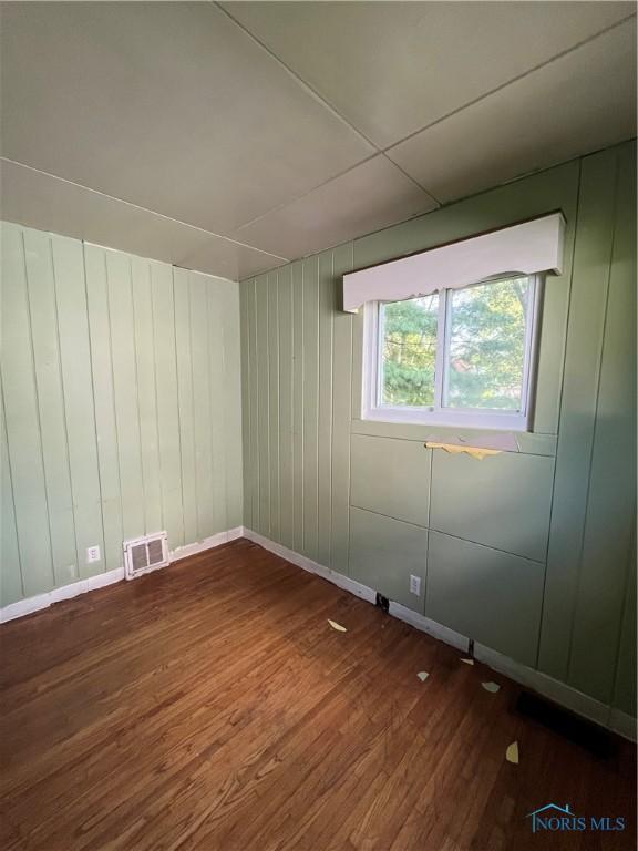 unfurnished room with wood-type flooring