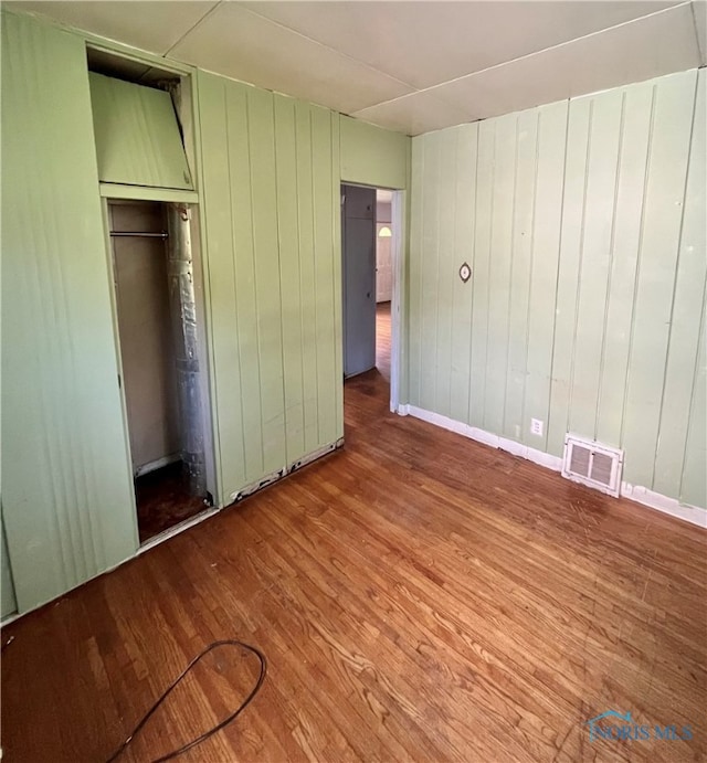 unfurnished bedroom featuring a closet and hardwood / wood-style floors