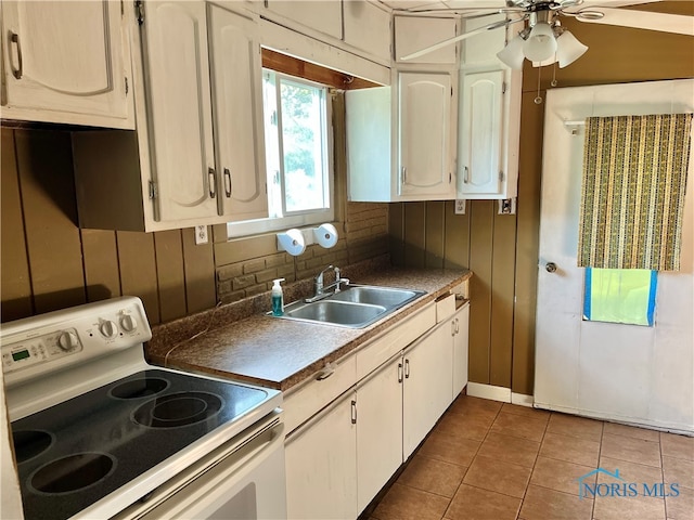 kitchen with electric stove, white cabinets, sink, tile patterned floors, and ceiling fan