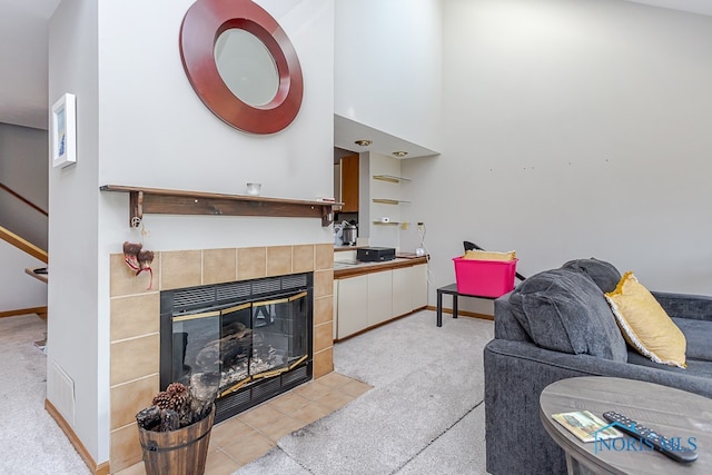 living room with a fireplace, a high ceiling, and light colored carpet