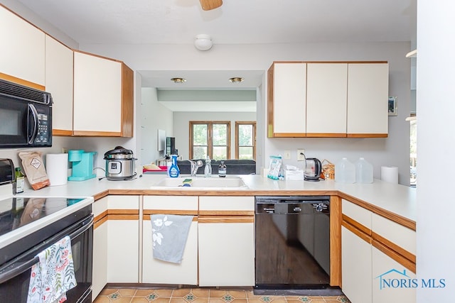 kitchen featuring sink, black appliances, white cabinets, light tile patterned floors, and kitchen peninsula