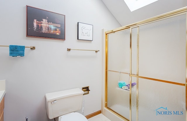 bathroom featuring vanity, tile patterned floors, lofted ceiling with skylight, toilet, and walk in shower