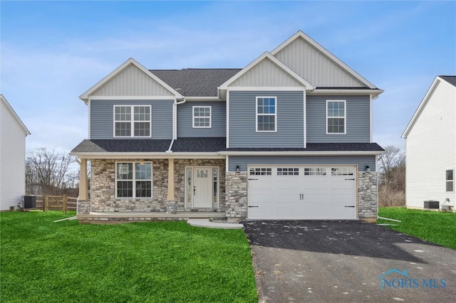 view of front of property featuring fence, driveway, an attached garage, central AC, and a front lawn