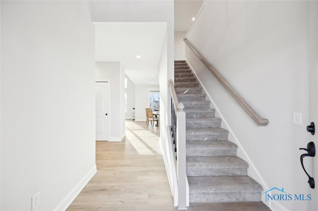 staircase featuring recessed lighting, baseboards, and wood finished floors