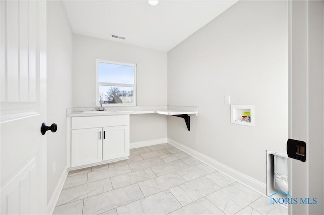 clothes washing area featuring visible vents, cabinet space, baseboards, and washer hookup