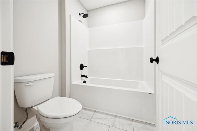 bathroom featuring toilet, marble finish floor, and bathtub / shower combination