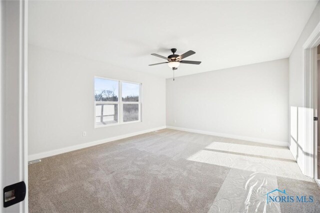 spare room featuring carpet flooring, baseboards, and ceiling fan