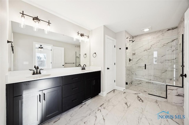 full bath featuring double vanity, marble finish floor, a marble finish shower, and a sink