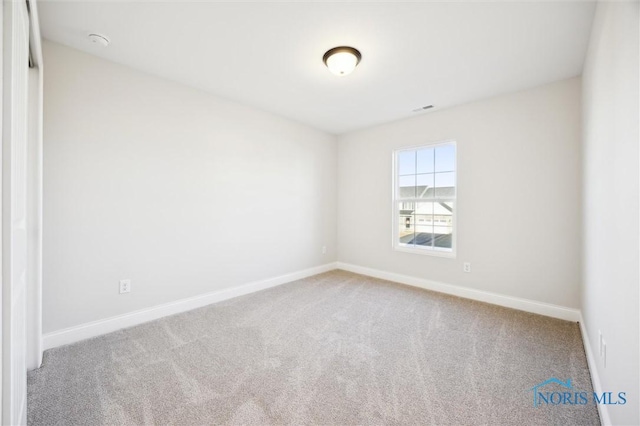 carpeted empty room with visible vents and baseboards