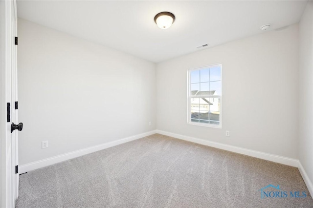 carpeted empty room with visible vents and baseboards