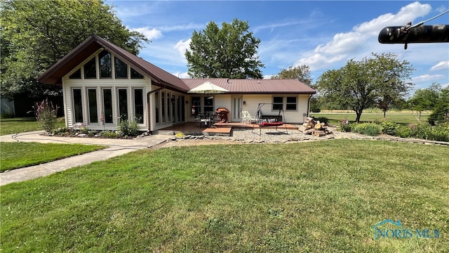 rear view of house with french doors, a deck, and a yard