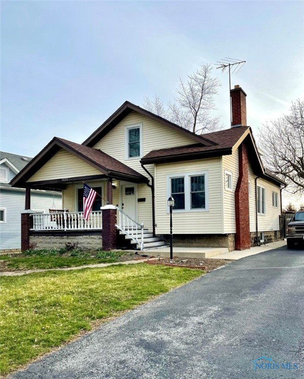 bungalow with a porch and a front yard